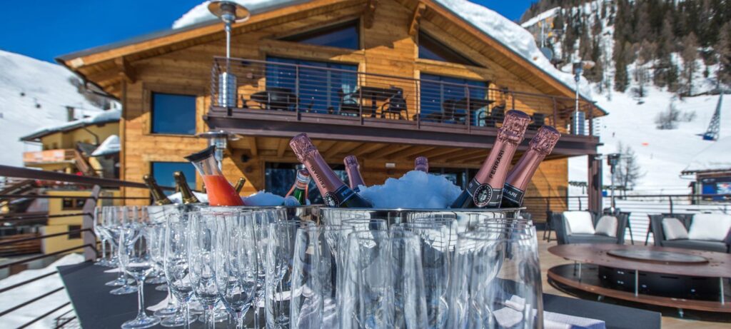 Champagne bottles in front of a ski chalet in Italy